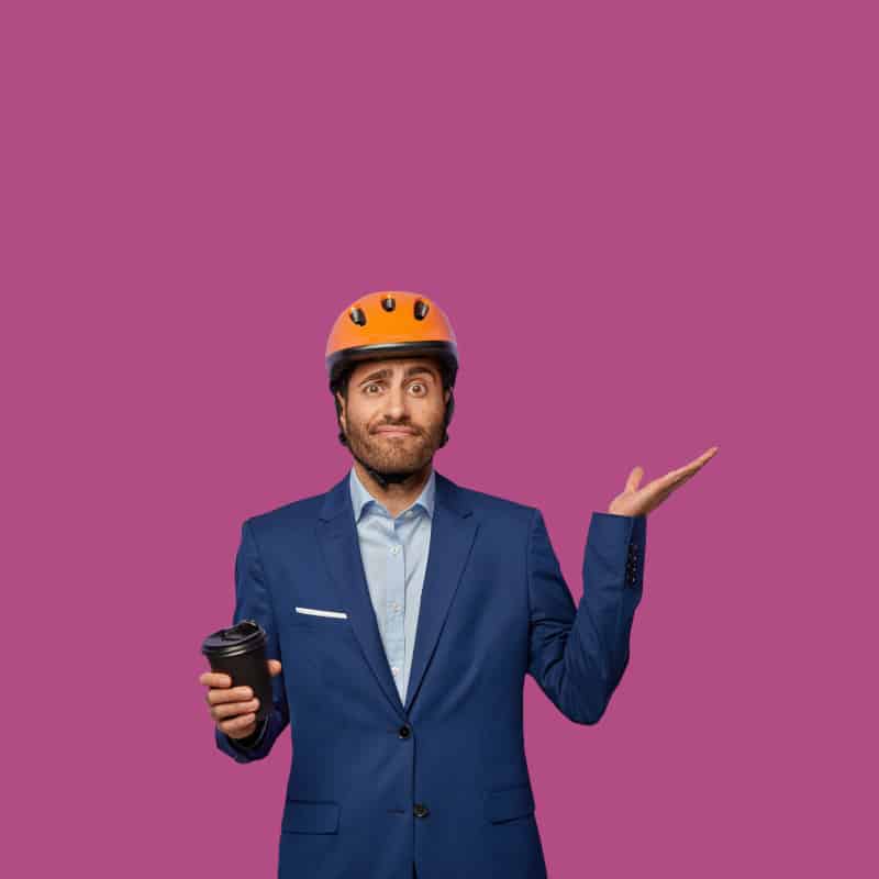 A man holding a coffee cup shrugs