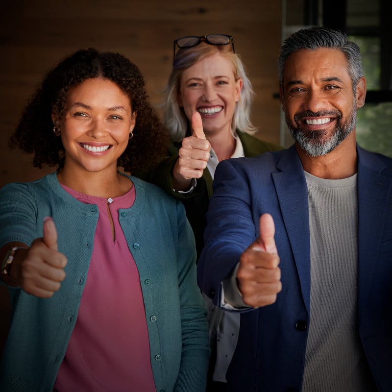 A group of smiling people giving a thumbs up sign of approval