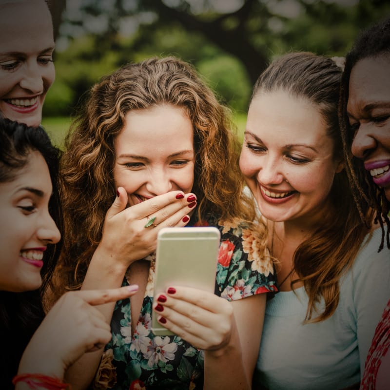 A group of women laughing at the answer to an online quiz