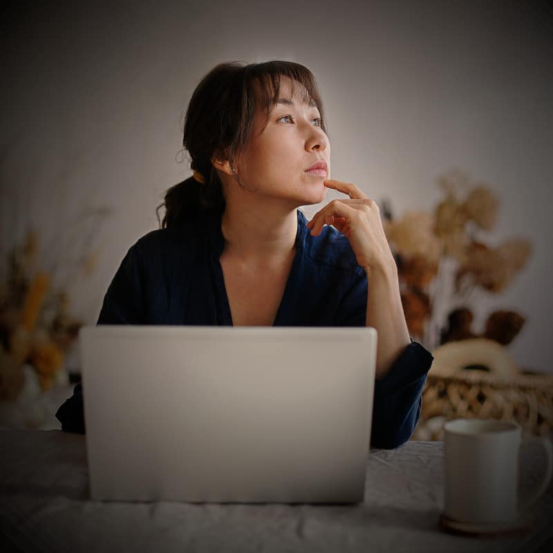 A woman thinking about how to best describe a product for her e-commerce store