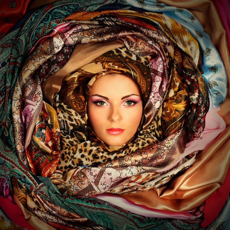 A very bespoke woman surrounded with scarves