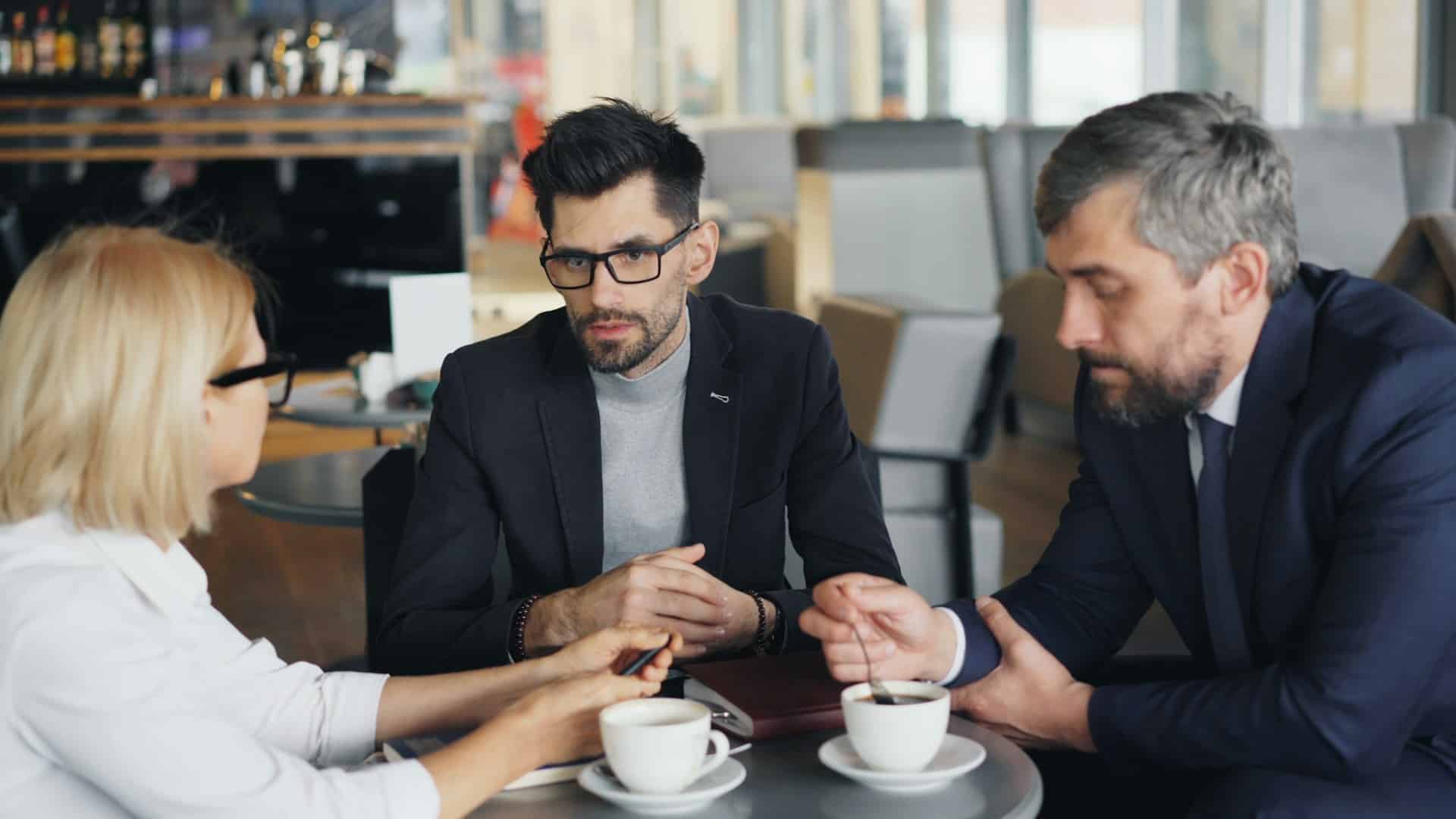 Three people swap ideas while business networking on Aucklands North Shore.
